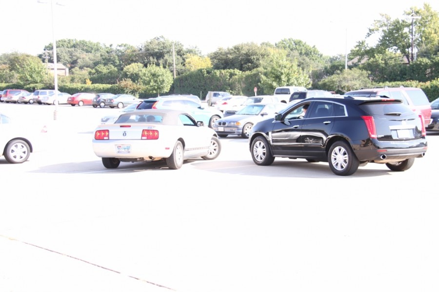 Junior Michael Sessions narrowly avoids an accident in his Ford Mustang convertible in the parking lot near D building while attempting to leave after 6th period. "Parking lot issues persist most in the afternoon," Sessions said. "Everyone is trying to back out at the same time and it causes chaos." Photo by Cameron Drummond. 