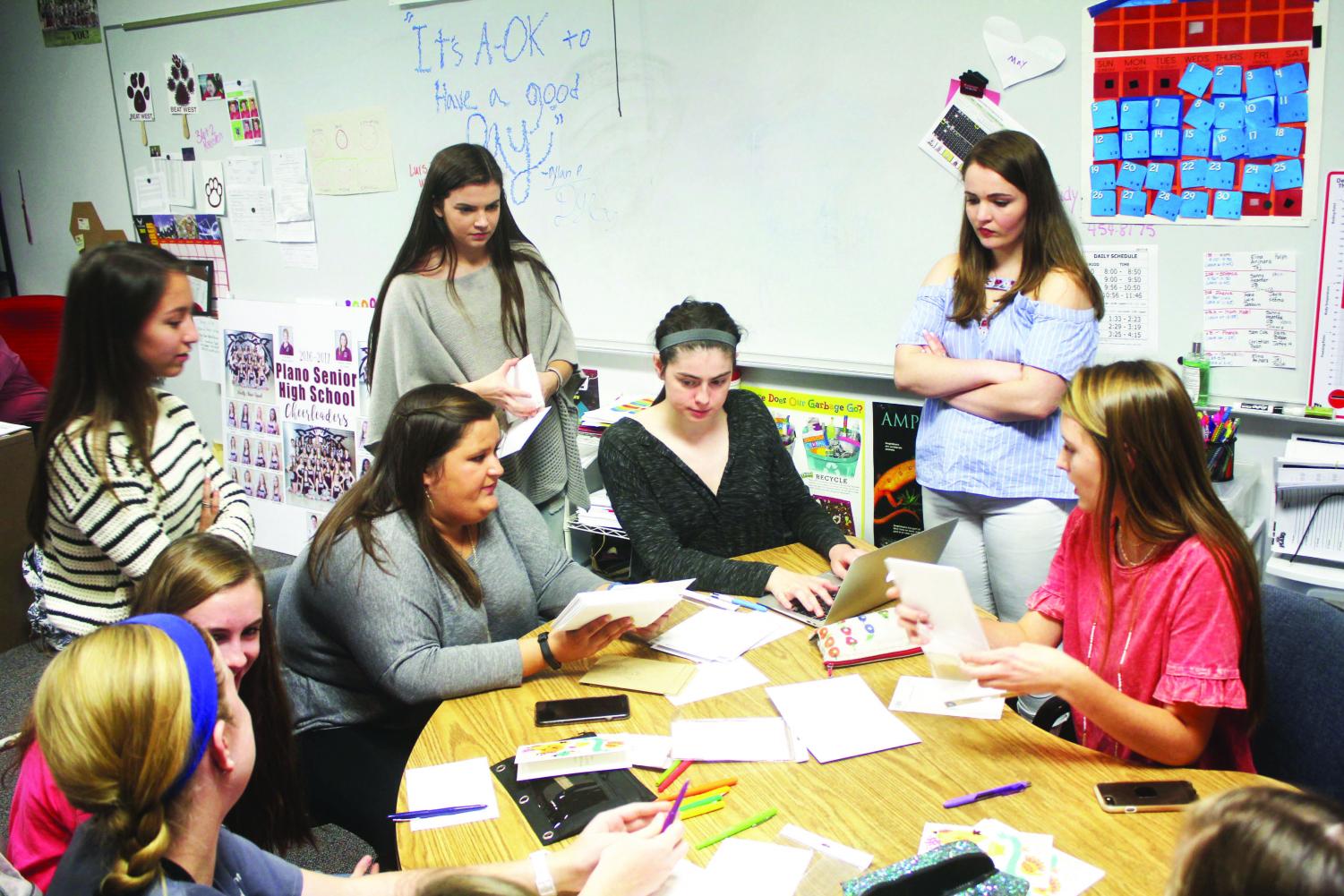 Senior Caitlyn Pierce, Claire McKinney, Megan Manly, Elyse Young, Kaylee Willman and juniors Sarah Bruner and Anna Smith write letters for Caring Cats.