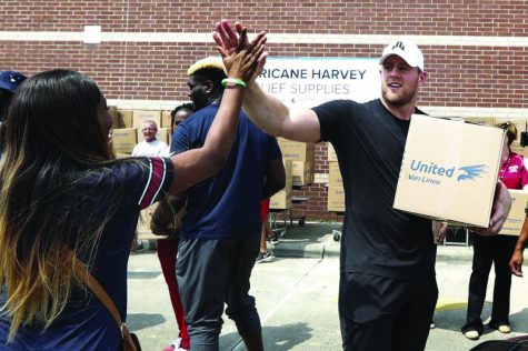 Houston Texans hero, JJ Watt high fives a fan as he helps to load boxes for hurricane relief. (photo by Getty Images, used with permission)