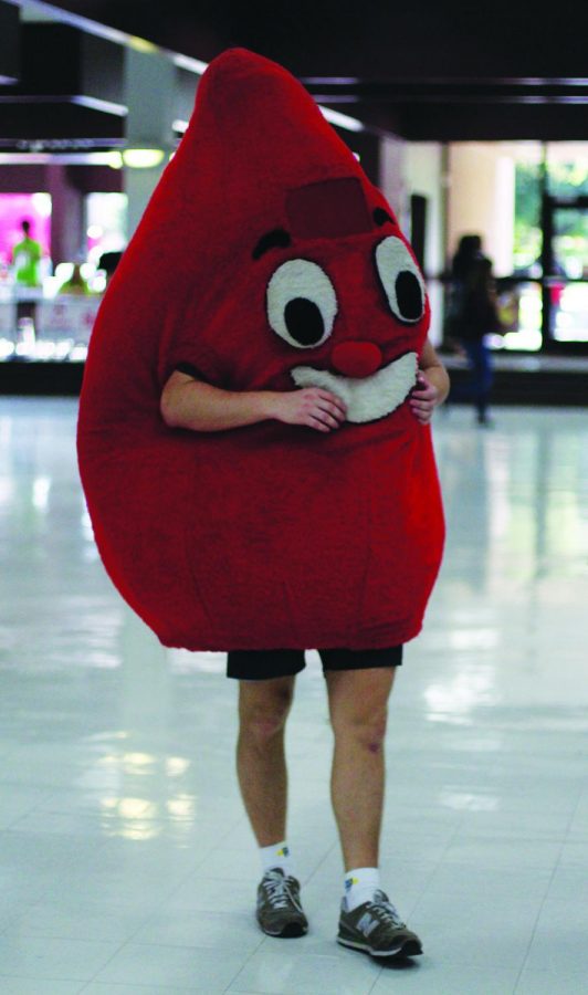 Student in BloodCare blood drop character suit entertains students waiting their turn to give
blood.