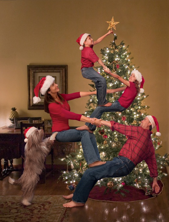 A family celebrating Christmas by decorating the tree all together enjoying the holiday.