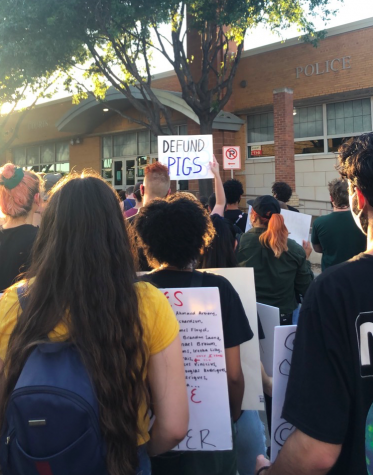 Protestors march outside of a police station