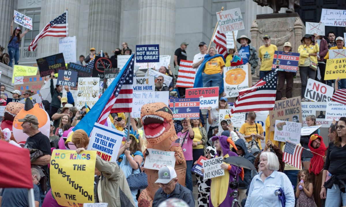 Protestors wave signs as thunder begins to rumble near the end of the No Kings demonstration at the Missouri State Capitol in Jefferson City, Missouri, Oct. 18, 2025 (Annelise Hanshaw/Missouri Independent).